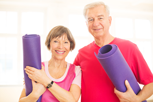 two patients smiling at the camera while in yoga